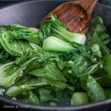 Increase to medium-high heat. Add in baby bok choy followed by water to help cook the veggies faster. Stir fry and cook until bok choy is softened, about 2-4 minutes.