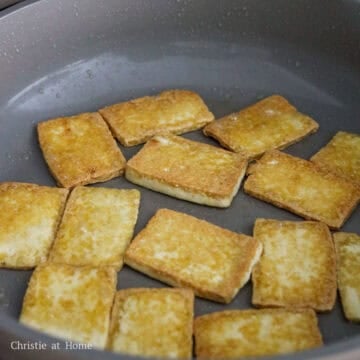 Heat vegetable oil or any neutral oil in a large pan on medium heat. Carefully lower tofu slices into the hot oil away from you. Fry tofu in small batches until golden brown on both sides, about 5-7 minutes per side.