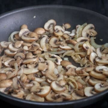 Toss in sliced mushrooms. Then add ¼ cup water. Cook until mushrooms have softened, about 5 minutes, and most of the liquids in the pan have evaporated. 