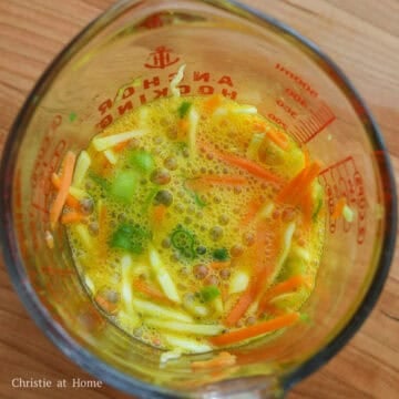 In a measuring cup with a lip or a small bowl, combine eggs, salt, cabbage, carrots and green onions and mix well. Set aside. 