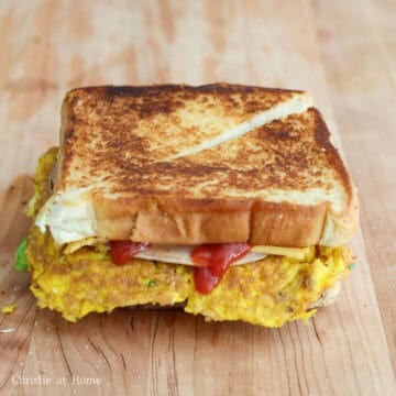 Close the sandwich with remaining slice of toast. Slice into half and enjoy hot! 