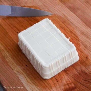 Dice soft tofu with a sharp knife into 1-inch cubes by horizontally gliding it through the middle of the block of tofu first. Then make vertical and horizontal slices across the block. This will give you about 1-inch cubes. 