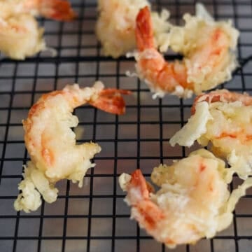 Remove with tongs or a slotted spoon and transfer to a wire rack or paper towel baking sheet to allow excess oil to drip off. Too much oil in the coating causes for soggy tempura. Repeat for the remaining shrimp. 