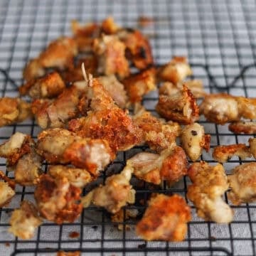 Remove and transfer fried chicken onto a wire rack resting on a baking sheet or a plate lined with paper towels to drain off excess oil. Pour out any excess oil from pan.