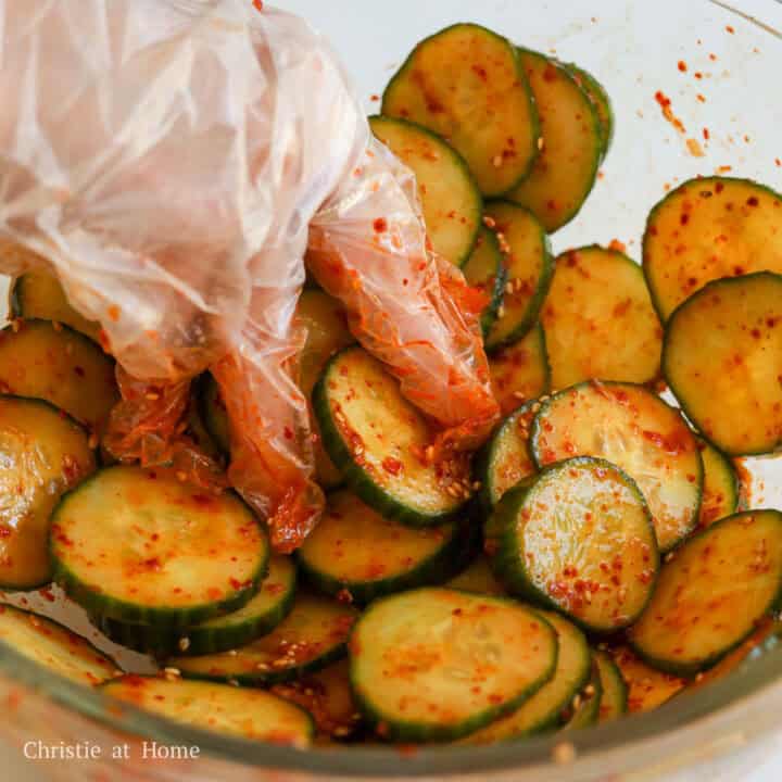 Korean cucumber salad with sliced cucumbers evenly coated in the spicy dressing.