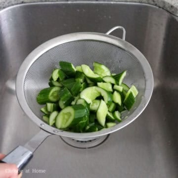 Strain the rinsed cucumbers removing as much excess water as possible.
