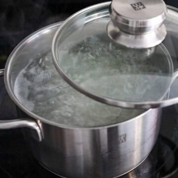 Add 5 cups water to a medium size pot. Bring to boil. Add in strained rice. Give it a stir. Then lower heat to medium heat. Do not stir the rice after this point as this causes the rice to stick to the bottom of pot. Boil for 22 minutes half covered with a lid to allow steam to escape. Do not cover fully.