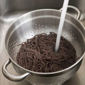 Strain noodles and rinse noodles off with cold running water until they are cool to touch. Strain out as much excess water as possible. Transfer strained noodles to a large bowl.