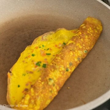 Pan fry until the omelette is mostly cooked and the edges lift away from the pan. Gradually roll it 75% of the way and gently flatten the egg roll with two spatulas so the layers can stick together. 