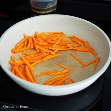 Next reduce to low-medium heat, add 1 teaspoon sesame oil and carrot matchsticks. Cook until they're softened, 1-2 minutes. Remove and set aside on a large plate.