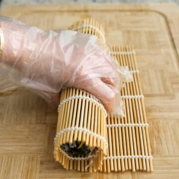 Firmly roll the kimbap away from you tightly tucking in the ingredients. Then  hold the roll until it’s set and doesn’t fall apart, about 10 seconds. Let the kimbap rest for a few minutes. Repeat this for the remaining three kimbap rolls. 