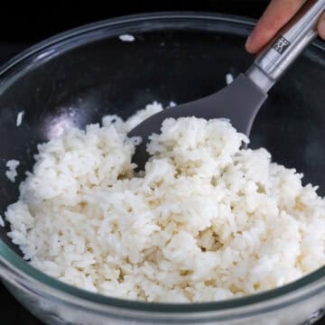 First in a large mixing bowl, season hot cooked rice with 2 teaspoon sesame oil and ½ teaspoon salt. Mix well. Keep covered and warm at room temperature to preserve the moisture in the rice and set aside. 