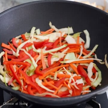 Add in remaining oil and sauté carrots, red bell pepper, and green cabbage for 60 seconds or until crisp and slightly tender.