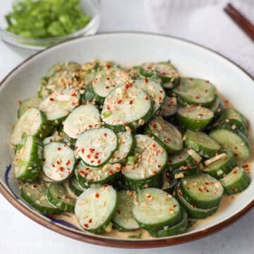 Mix the dressing into the sliced cucumbers and transfer to a serving plate. Garnish with sesame seeds. Serve and enjoy immediately. 