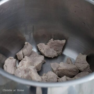 Discard the water, rinse the meat and the pot and add meat back to the pot.